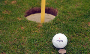 Golfball mit Münze als Marker