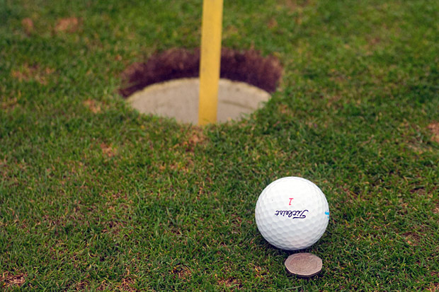 Golfball mit Münze als Marker